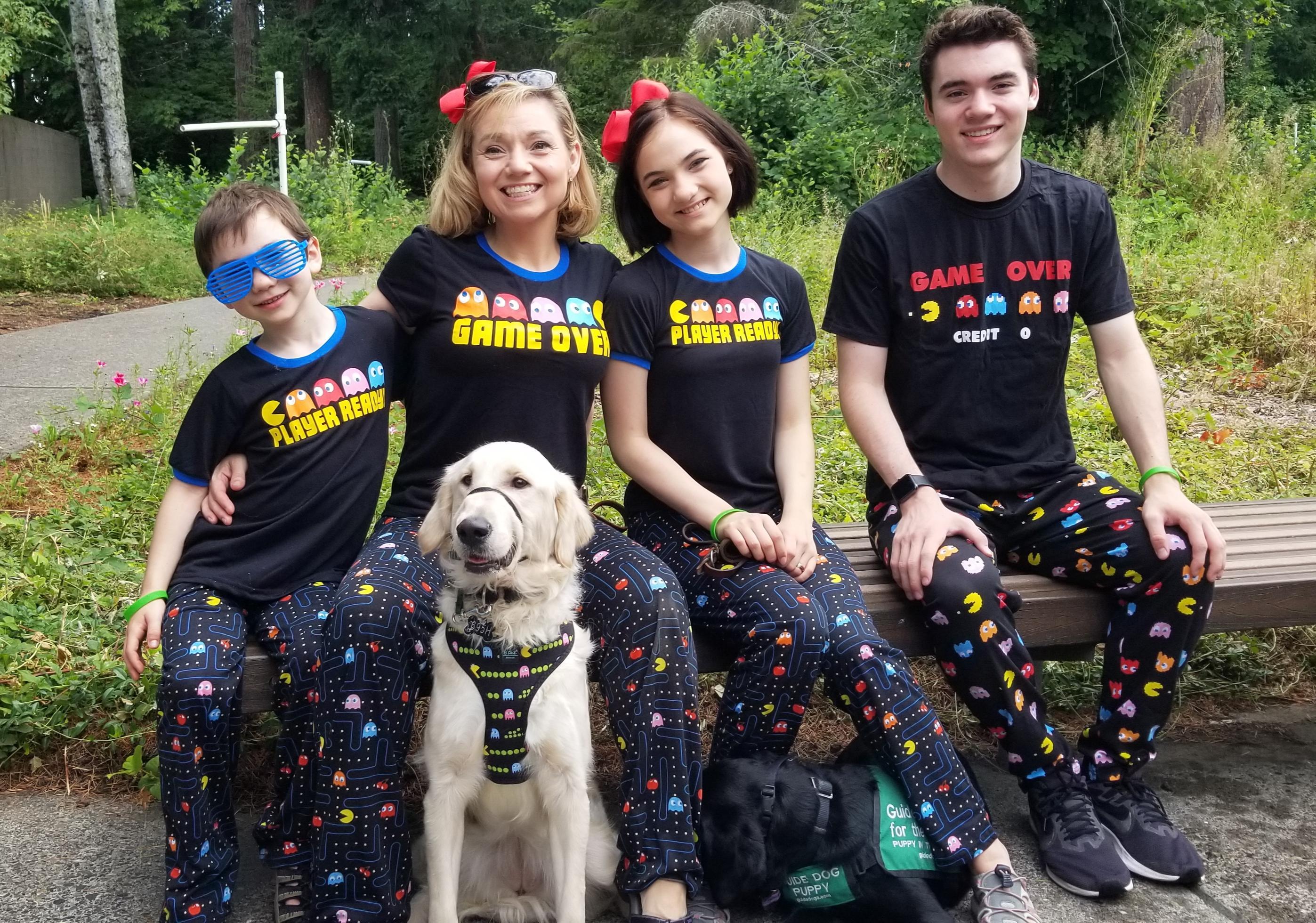 The Crispin Family of four donned in matching 80s themed outfits poses with GDB puppy, Chamberlin, a black Lab.