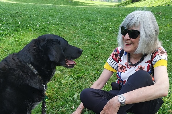 A woman and a black Lab dog.