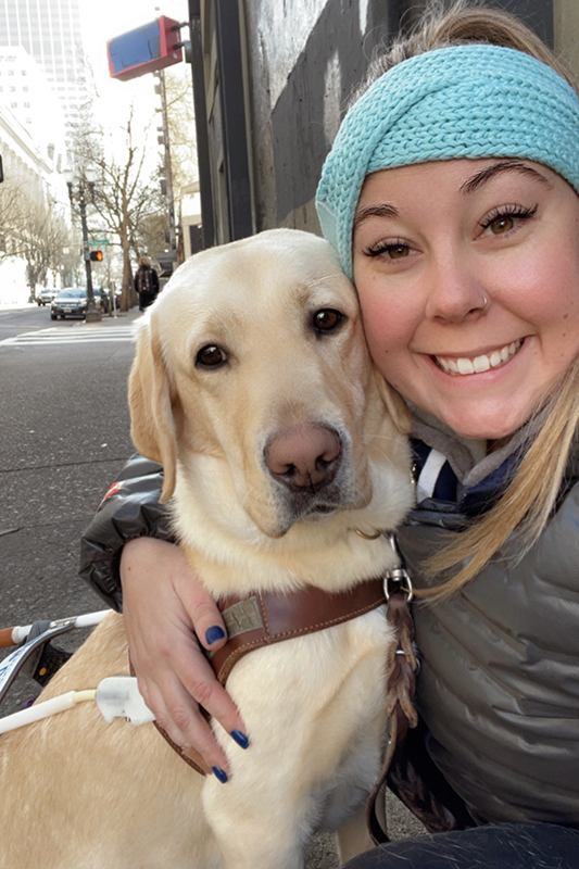 Meagan Foertsch with a yellow Lab guide dog.