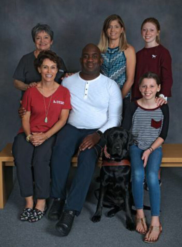 Abdul Kamara and his black Lab guide dog Faye with Annie Martin, Gail Martin, and Jessica Firkins with her daughers Ariss Firkins and Cerelle Firkins.