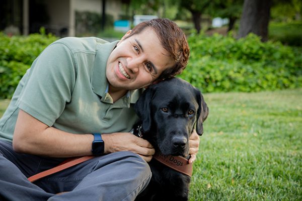 Belo Miguel Cipriani hugs his black Lab guide dog, Limo