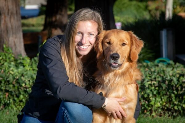 Guide Dog Mobility Instructor Chelsea Sims with a Golden Retriever guide dog.