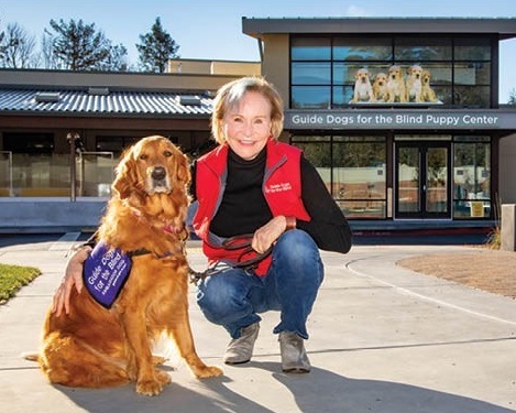 President and CEO of GDB and her Golden Retriever ambassador dog in front of the Puppy Center.