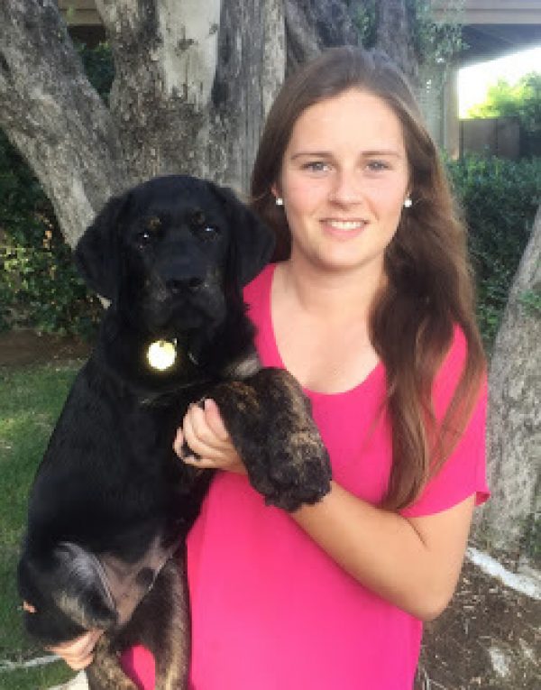 Puppy raiser Megan Iriving with a black Lab puppy